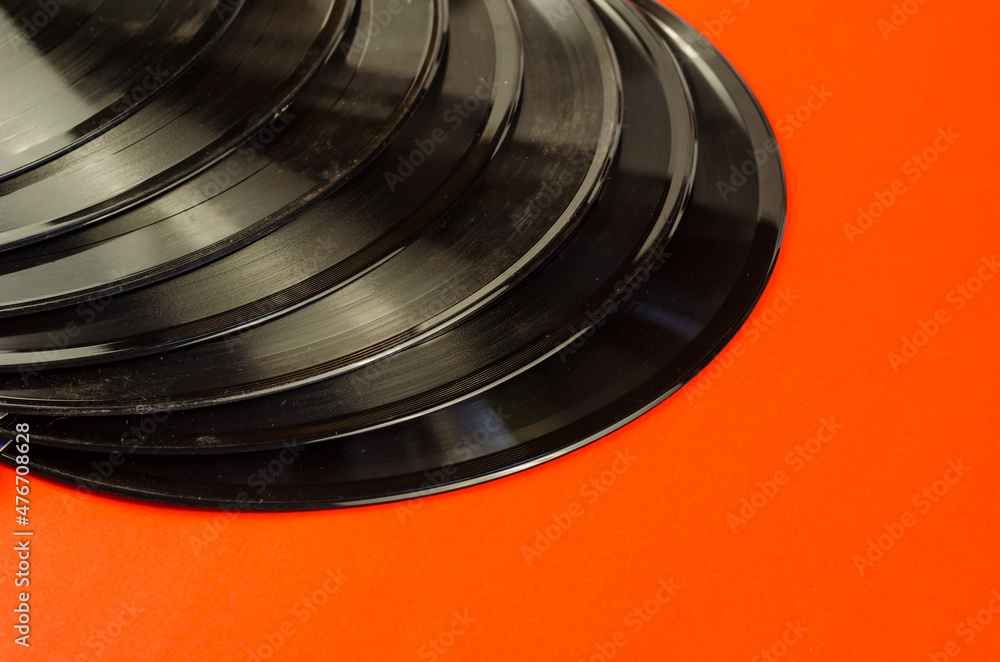 Old vinyl records on a red background. A group of gramophone rec