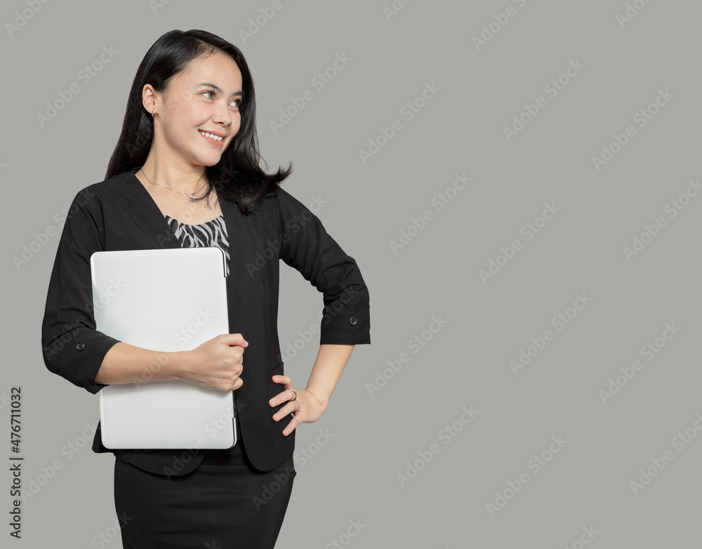 Beautiful business woman holding laptop and looking at empty space Beautiful business woman holding laptop and looking at empty space