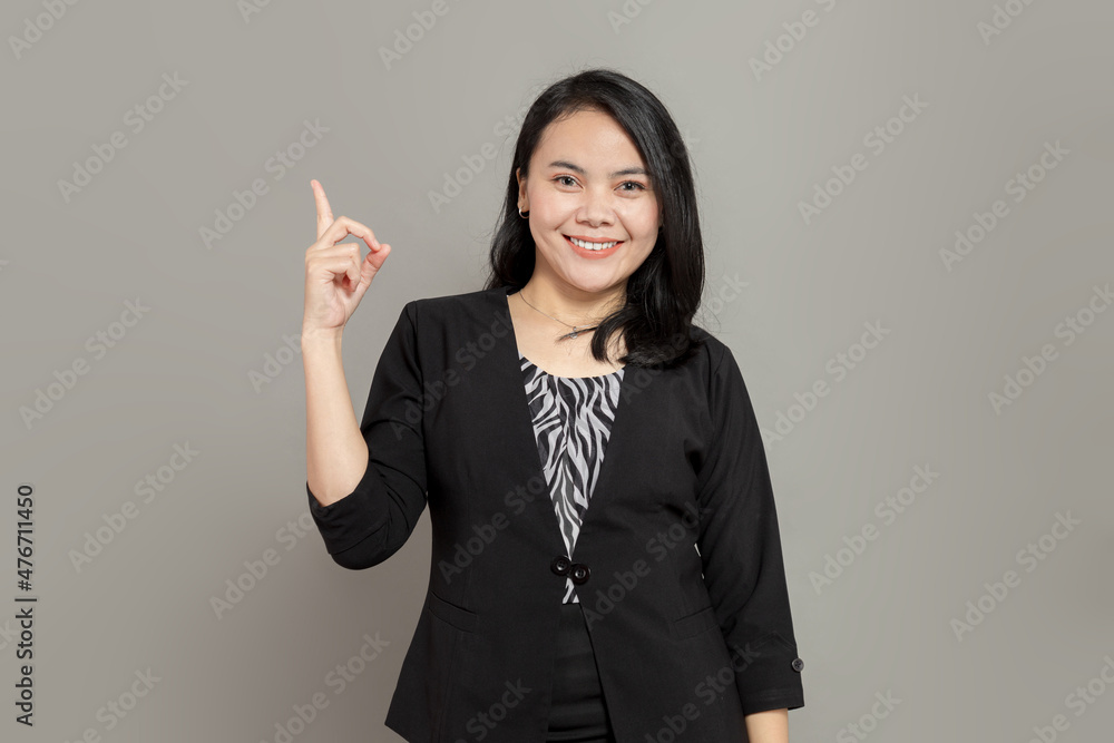 Business woman pointing up with one hand while smiling Business woman pointing up with one hand while smiling