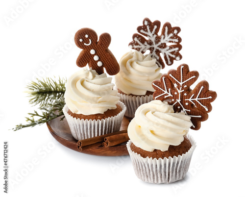 Plate of tasty Christmas cupcakes with gingerbread cookies on white background