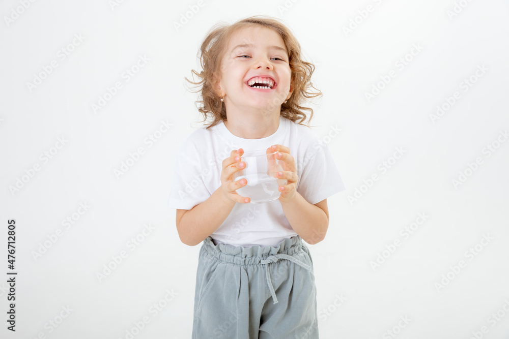 a little girl in a white t-shirt holding a glass of water isolated on a white background a little girl in a white t-shirt holding a glass of water isolated on a white background