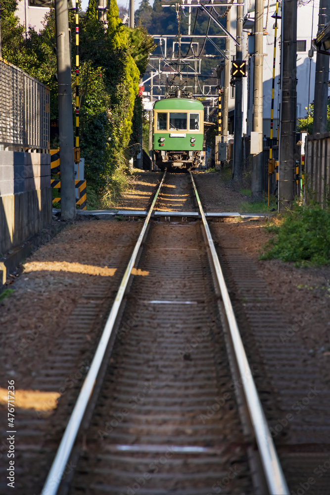 Naklejka premium 住宅の裏の狭い隙間を走るローカル線