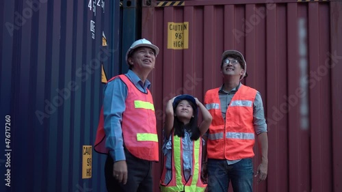 Happy family standing with crossed arms at container cargo site, Cheerful father daughter and senior engineers in a shipyard
