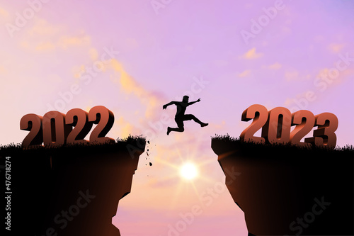 Murais de parede Welcome Merry Christmas and Happy New Year in 2023, Vector black silhouette man jumping from 2022 cliff to 2023 cliff with cloudy sky and sunlight