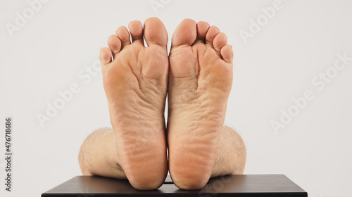 Asian Male soles of feet and barefoot are isolated on chair with white background. photo