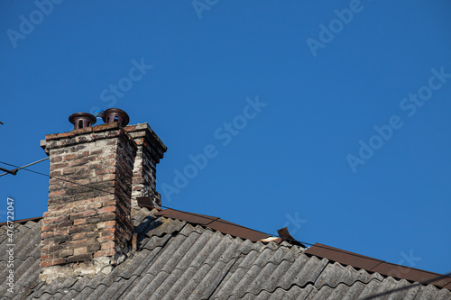 The roof of the house is made of red metal tiles, a beautiful large chimney