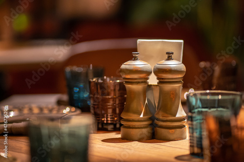 Close-Up Of Pepper Salt Seasoning Wooden Glinders On Table. Salt and pepper shakers on wooden table