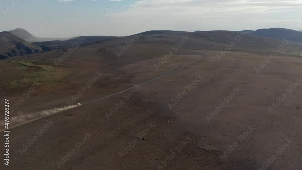 Aerial view car driving in desert stony highlands in Iceland. Drone view vehicle 4x4 speeding off road on pathway in rocky volcanic icelandic desert. Commercial insurance Aerial view car driving in desert stony highlands in Iceland. Drone view vehicle 4x4 speeding off road on pathway in rocky volcanic icelandic desert. Commercial insurance