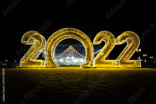 Happy New Year 2022. Sparkling burning numbers Year 2022 with on black background. christmas street decorations. Beautiful design element.