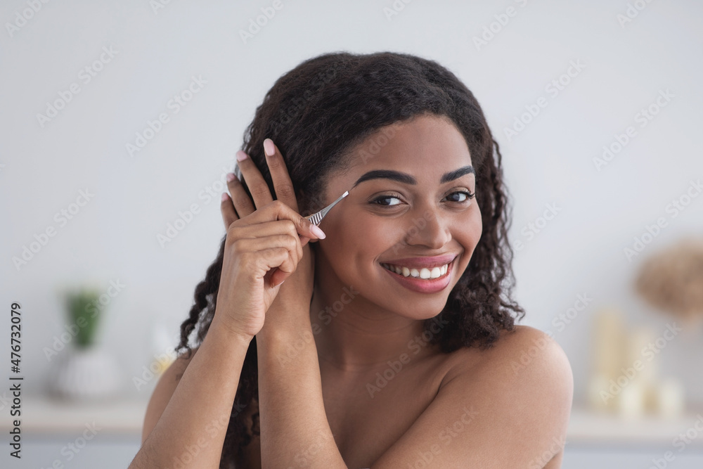 Woman with natural beauty plucking eyebrows at home Woman with natural beauty plucking eyebrows at home