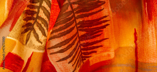 Texture. Background. Template. red and yellow brown silk fabric with abstract pattern, print made of fern twigs