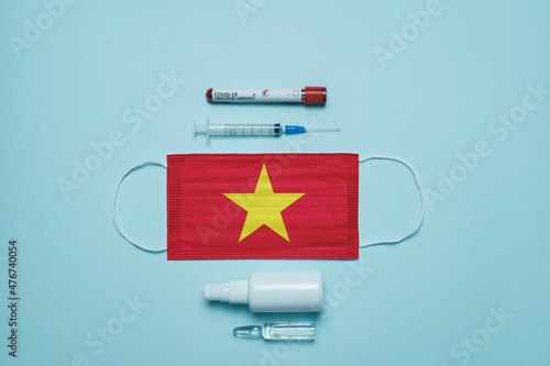 Blood tube for test detection of virus Covid-19 Omicron Variant with positive result, medicine mask with Vietnam flag superimposed and vaccine.  New Variant of the Covid-19 Omicron