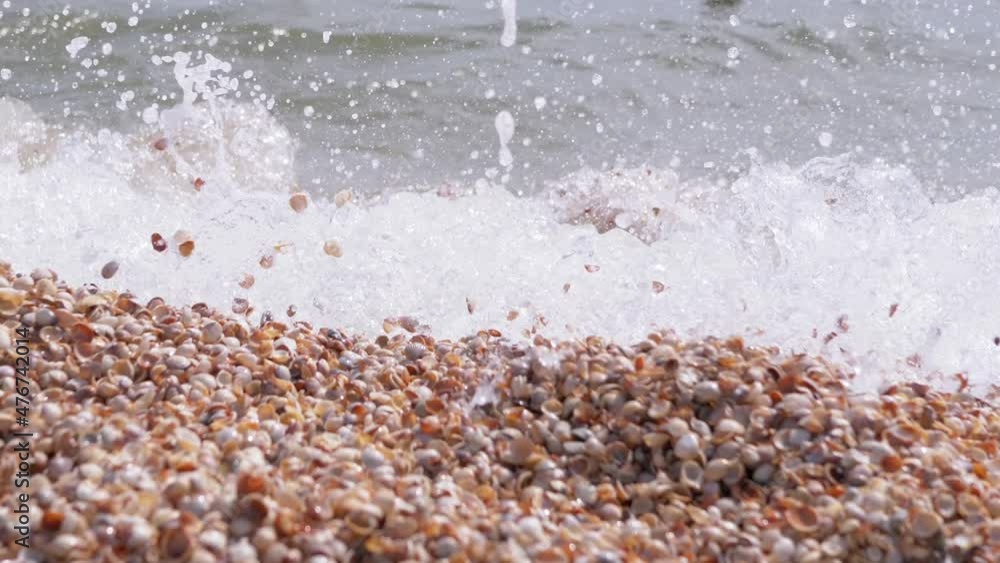 Sea Wave with Foams Rolls onto the Sandy Shore from Shells. Splashes ...