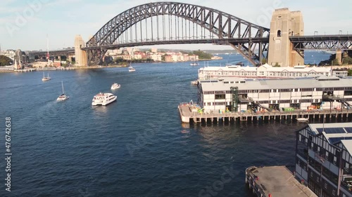 Drone aerial pan up of Sydney Harbour Bridge from Walsh Bay Port Jackson with boats yacht and ships NSW Australia City tourism 4K photo