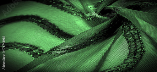 texture background picture the fabric is transparent emerald green with brightly innate stripes, the material allowing the light to pass through it so that the objects behind are clearly visible