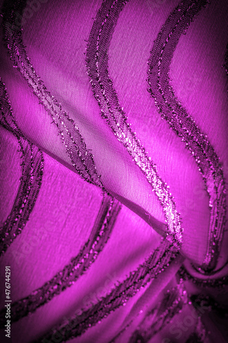 the ornament of the decor, the transparent fabric is purple-red with brightly innate stripes, the material allowing the light to pass through it so that the objects behind are clearly visible