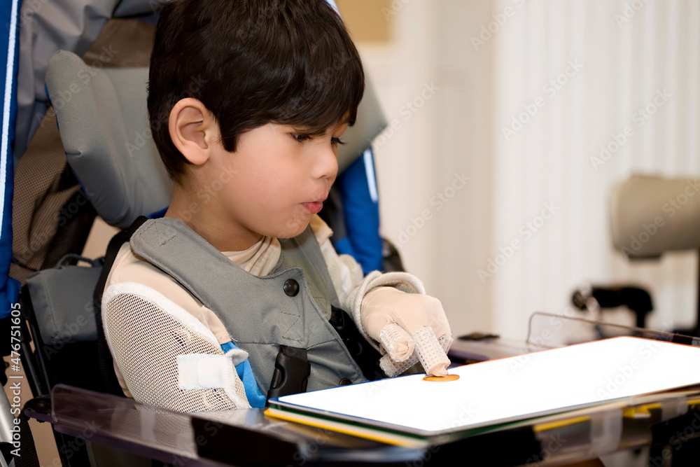 Little boy with disability studying in wheelchair at home Little boy with disability studying in wheelchair at home