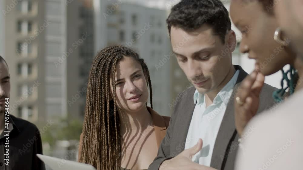 Close-up shot of business partners working together outdoor. Side view of Caucasian businessman in official suit holding laptop talking with colleagues, discussing work issues. Teamwork concept Close-up shot of business partners working together outdoor. Side view of Caucasian businessman in official suit holding laptop talking with colleagues, discussing work issues. Teamwork concept