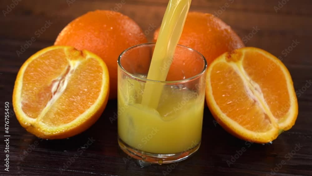 A glass of fresh orange juice served for detox beverage. Man pouring fresh detox orange juice in glass for refreshment. Fresh detox orange juice drink can boost vitamin C. Healthy lifestyle concept. A glass of fresh orange juice served for detox beverage. Man pouring fresh detox orange juice in glass for refreshment. Fresh detox orange juice drink can boost vitamin C. Healthy lifestyle concept.