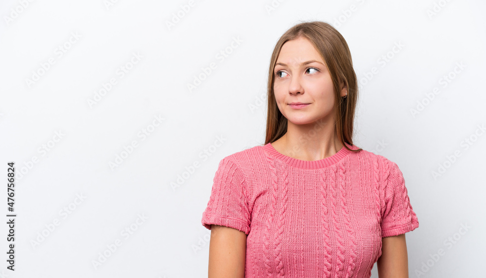 Young Russian woman isolated on white background having doubts while looking side Young Russian woman isolated on white background having doubts while looking side