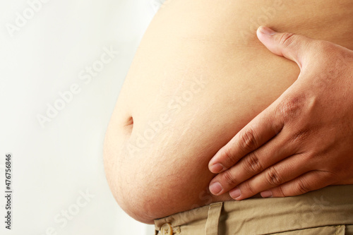 fat mature man check out body overweight abdomen his belly for white or obesity background. Weight loss concept.