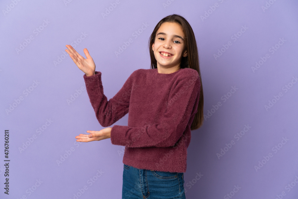 Little girl isolated on purple background extending hands to the side for inviting to come Little girl isolated on purple background extending hands to the side for inviting to come