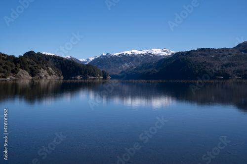 View of volcano Batea Mahuida  Andes mountains  forest and Alumine lake in Villa Pehuenia  Patagonia Argentina. Beautiful landscape and blue sky reflection in the glacier water. 