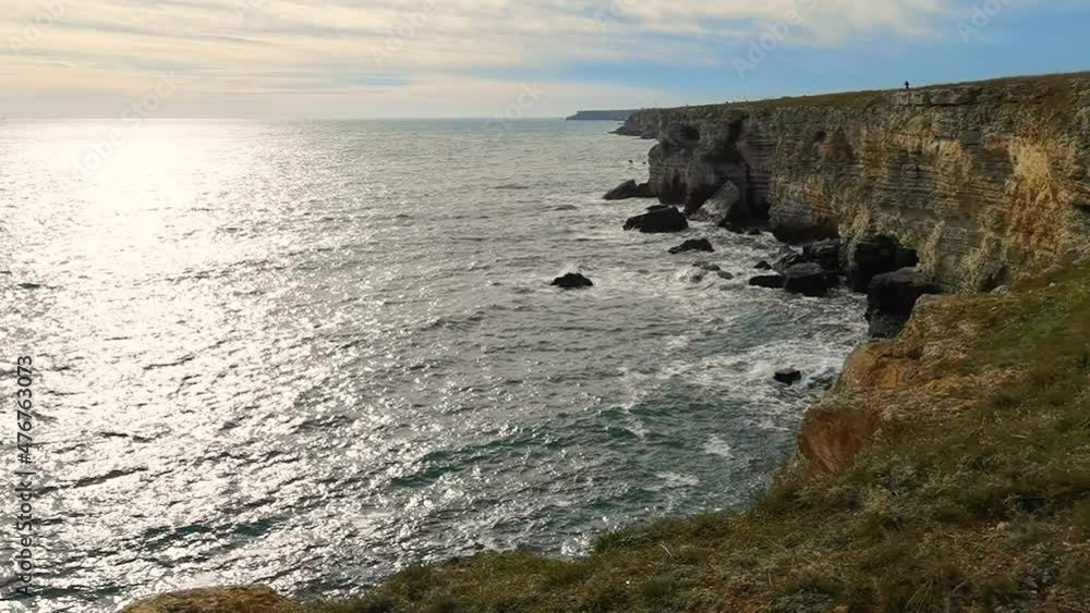 Scenic view of sun and clouds over the sea and rocky coast Scenic view of sun and clouds over the sea and rocky coast