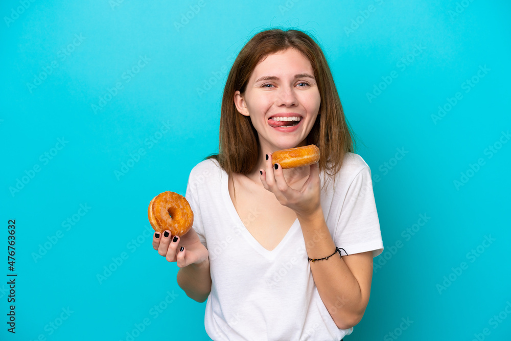Young English woman isolated on blue background holding a donut