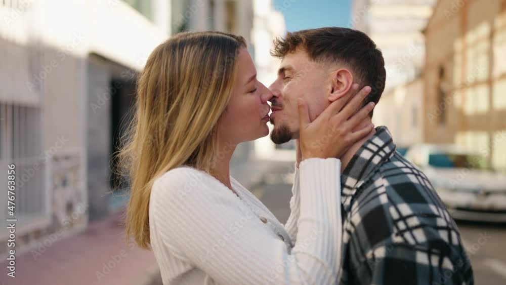 Young couple kissing and hugging each other standing at street Young couple kissing and hugging each other standing at street