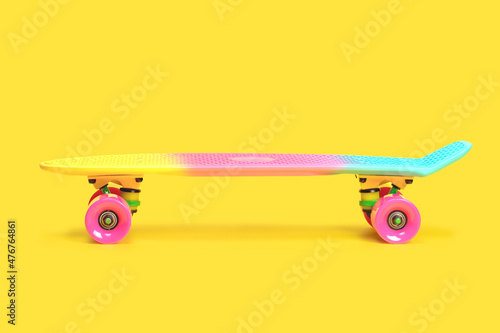Fotografia Pastel neon rainbow colored Penny board skateboard isolated on solid yellow background