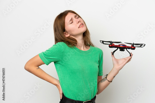 Young English woman holding a drone isolated on white background suffering from backache for having made an effort