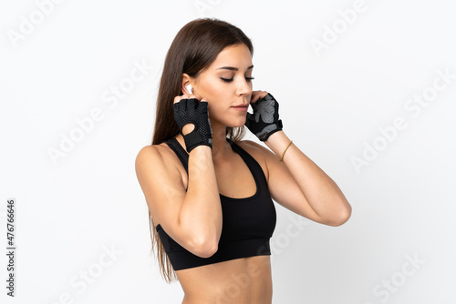 Young sport woman isolated on white background listening music © luismolinero
