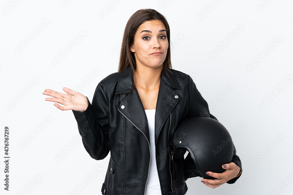 Caucasian girl holding a motorcycle helmet on white background having doubts with confuse face expression Caucasian girl holding a motorcycle helmet on white background having doubts with confuse face expression