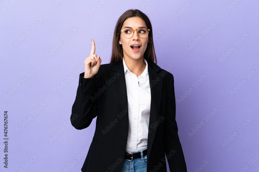 Business woman isolated on purple background intending to realizes the solution while lifting a finger up Business woman isolated on purple background intending to realizes the solution while lifting a finger up