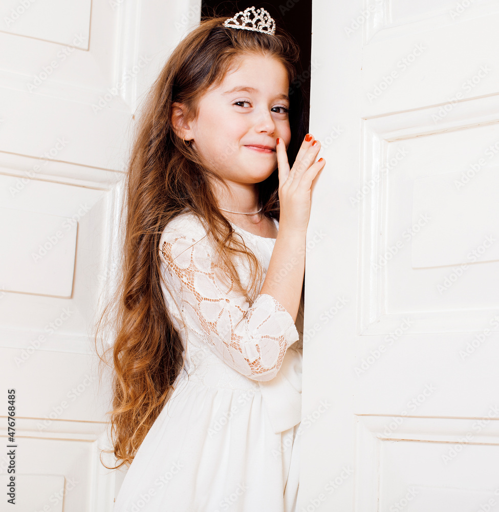 Φωτογραφία little cute girl at home, opening door well-dressed in white dress, adorable mil