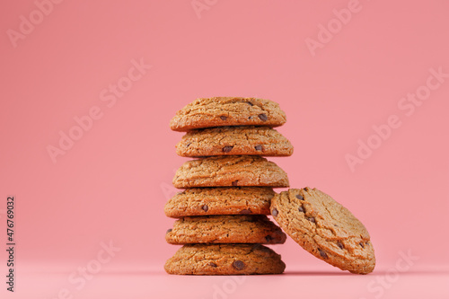 Oatmeal cookies stacked on a pink background.