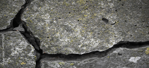 Shallow depth of field. Photo is blurred. Cracked concrete. Cracks in concrete are caused by internal tensile stresses caused by external forces, volume changes and creep.