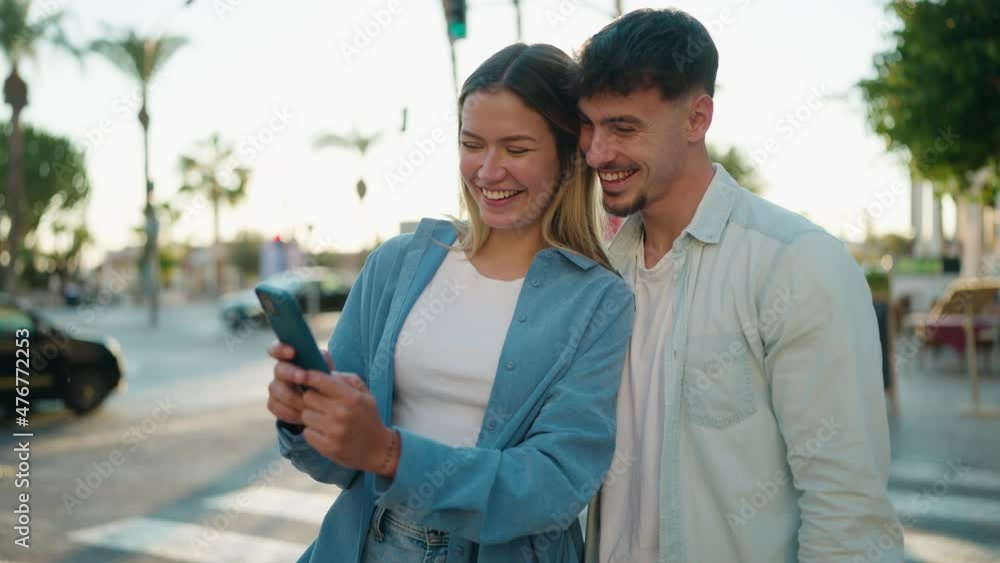 Young couple smiling confident using smartphone at street Young couple smiling confident using smartphone at street