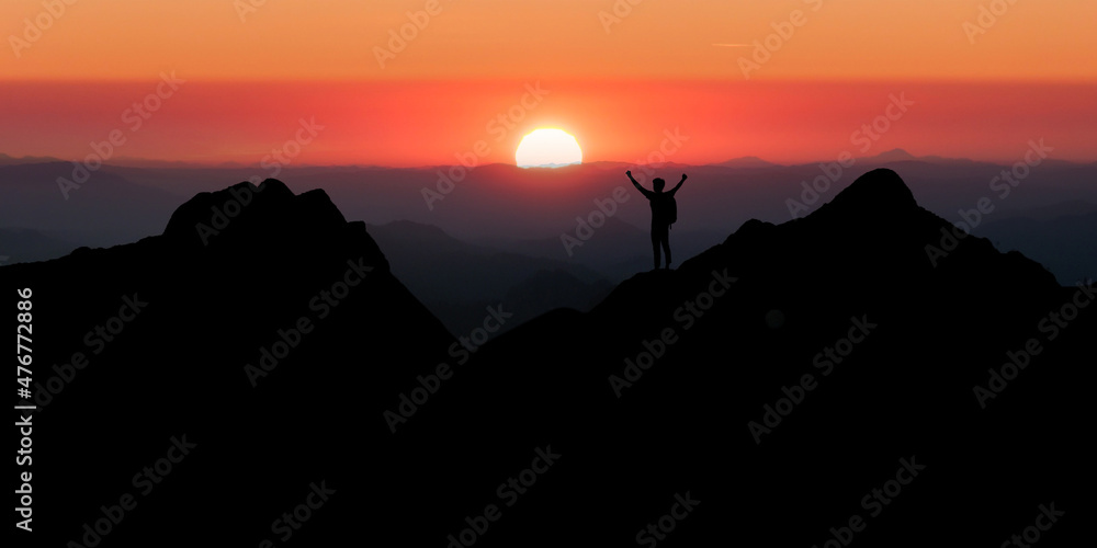 Young traveler looking beautiful view sunrise on top of mountain. He strong confidence woman open arms under the sunrise. He enjoyed traveling and was successful when he reached the summit.