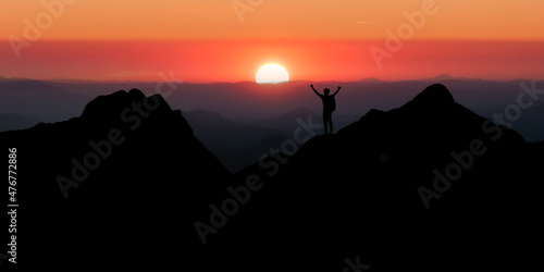 Young traveler looking beautiful view sunrise on top of mountain. He strong confidence woman open arms under the sunrise. He enjoyed traveling and was successful when he reached the summit.