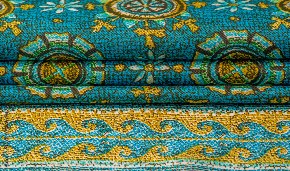 turquoise silk fabric with yellow drawings of flowers circles. Charmeuse has a beautiful drapery. This can be assembled in soft completeness.