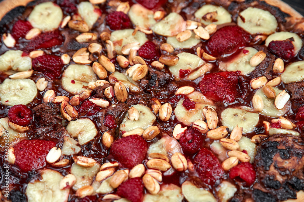 Sweet pizza with chocolate and fruits on black background Sweet pizza with chocolate and fruits on black background