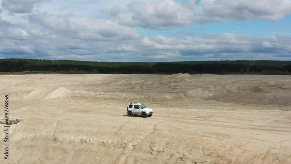 Aerial view of a car driving on sand Aerial view of a car driving on sand