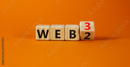 WEB 2 or 3 symbol. Turned a wooden cube and changed words WEB 2 to WEB 3. Beautiful orange table, orange background, copy space. Business, technology and WEB 2 or 3 concept.