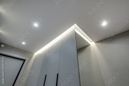 suspended ceiling with halogen spots lamps and drywall construction in empty room in apartment or house. Stretch ceiling white and complex shape.