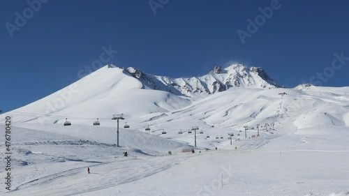 Erciyes Mountain summit in Kayseri view from east with skiers are skiing and ski lift is running photo