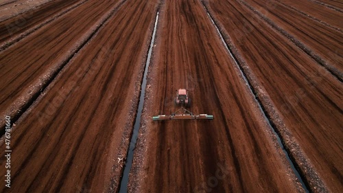 Peat Harvester Tractor on Collecting Extracting Peat. Mining and harvesting peatland. Area drained of the mire are used for peat extraction. Drainage and destruction of peat bogs.
