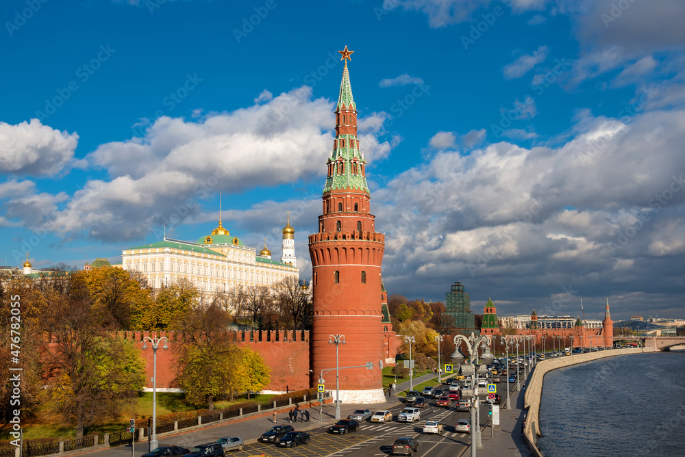 View of the Moscow Kremlin and car traffic along the Kremlin Embankment of Moscow River on a autumn day View of the Moscow Kremlin and car traffic along the Kremlin Embankment of Moscow River on a autumn day