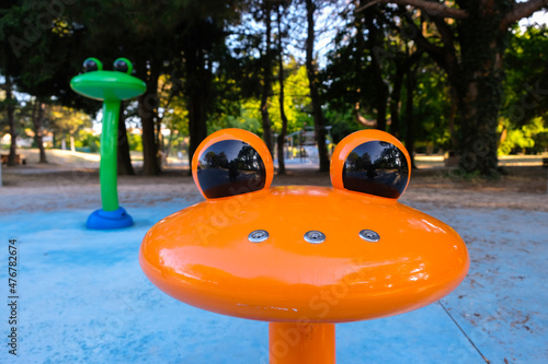 Metal orange frog fountain in the park. Holes for water on the nose of the frog. Modern fountains design. photo